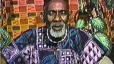 A group of people are sitting in a room with a man standing in front of them.