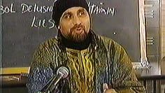 A white angel 's wings are spread out in the dark.