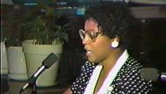 A hand is holding a tray with fruits and a smoothie on it