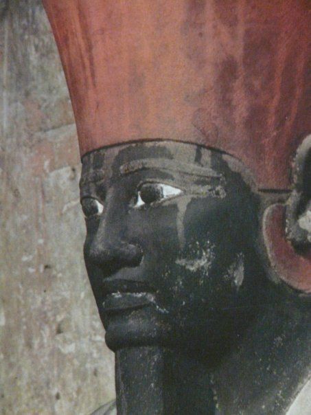 A close up of a statue of a man wearing a red hat.