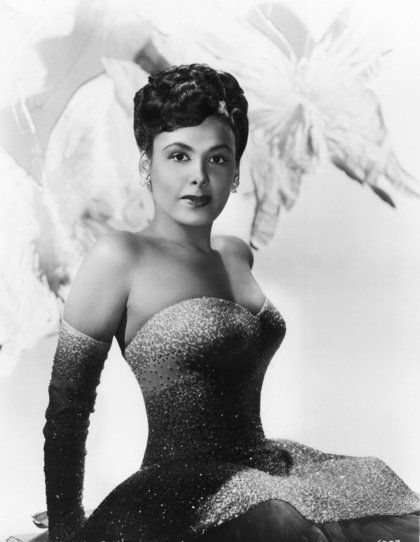 A black and white photo of a woman in a strapless dress