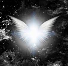 A white angel 's wings are spread out in the dark.