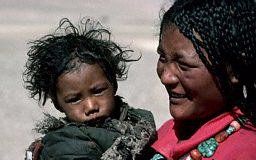 A woman is holding a small child in her arms.