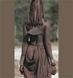 A woman in a brown dress is standing in a field.