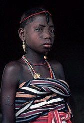 A young girl is wearing a striped top and a necklace.