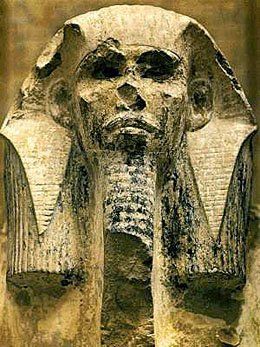 A close up of a statue of a pharaoh with a long beard.
