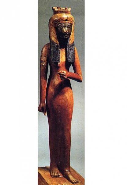A statue of a woman in a long dress is standing on a pedestal.