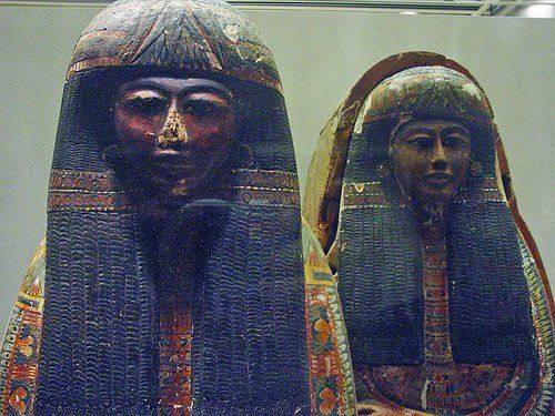 Two statues of a man and a woman are sitting next to each other