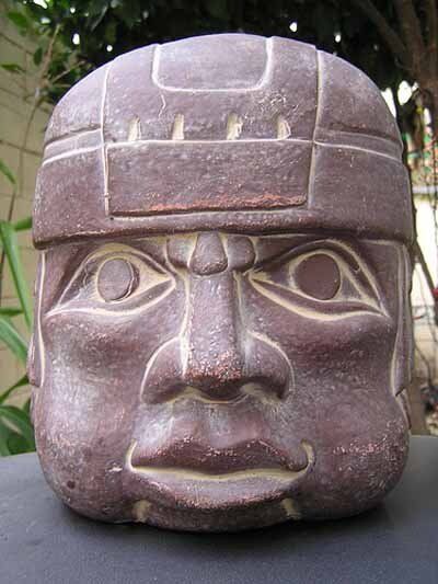 A statue of a man 's head is sitting on a table.