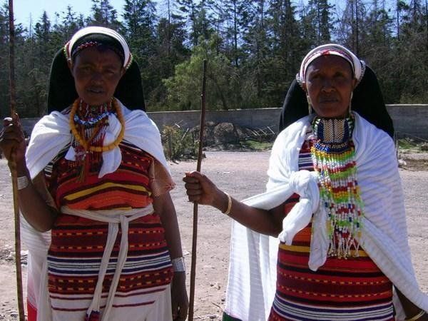 Two women standing next to each other holding sticks