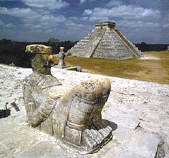 There is a pyramid in the background and a statue in the foreground.