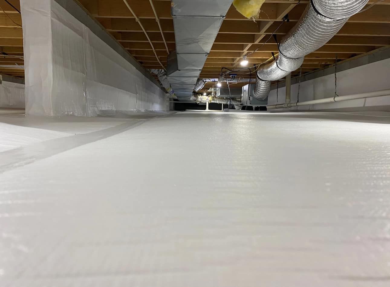 A basement with a lot of ducts coming out of the ceiling.