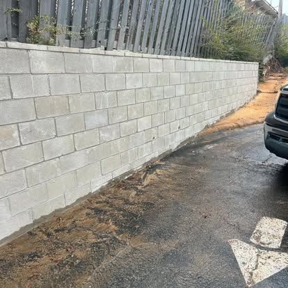 A truck is parked in front of a brick wall.