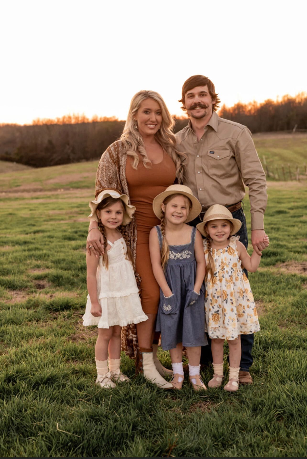 A family is posing for a picture in a field.