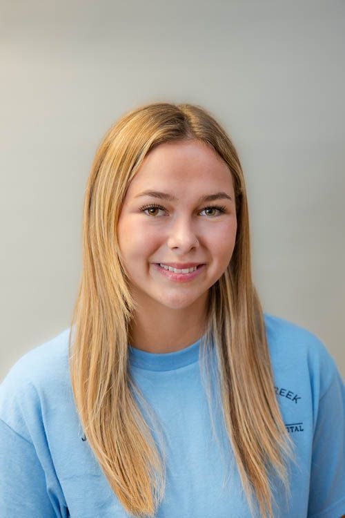 A group of people standing in front of a sign for sugar creek animal hospital
