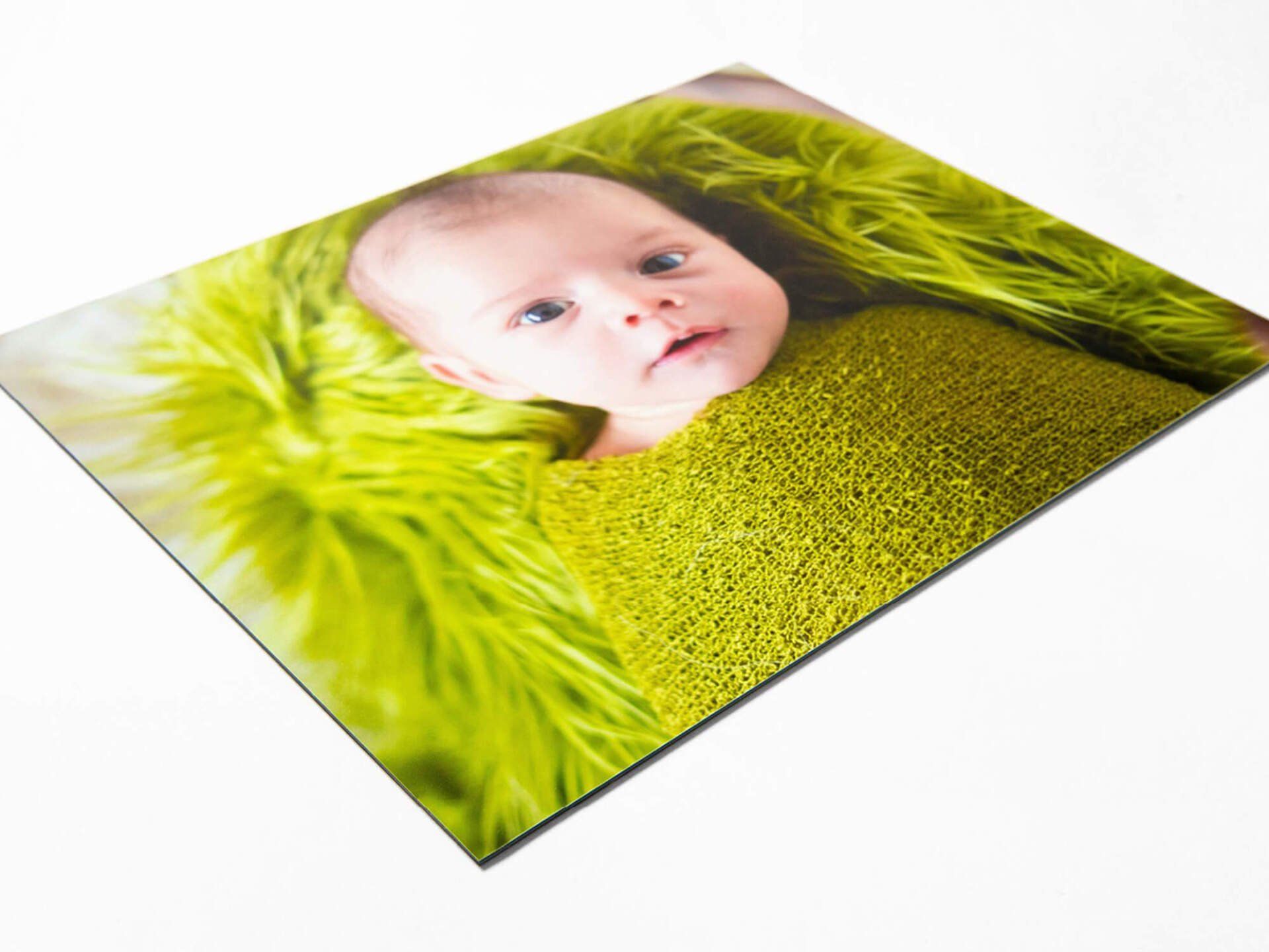 A picture of a baby wrapped in a green blanket