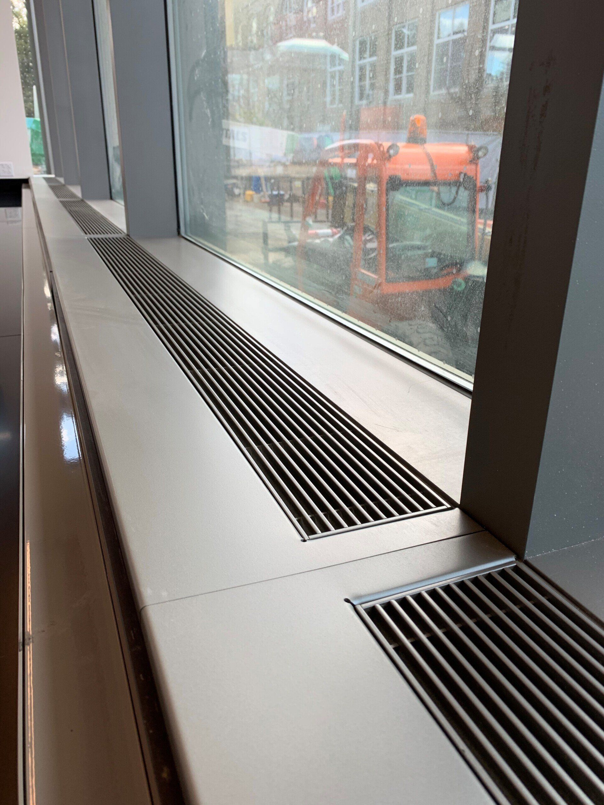 A large window with a stainless steel radiator underneath it.