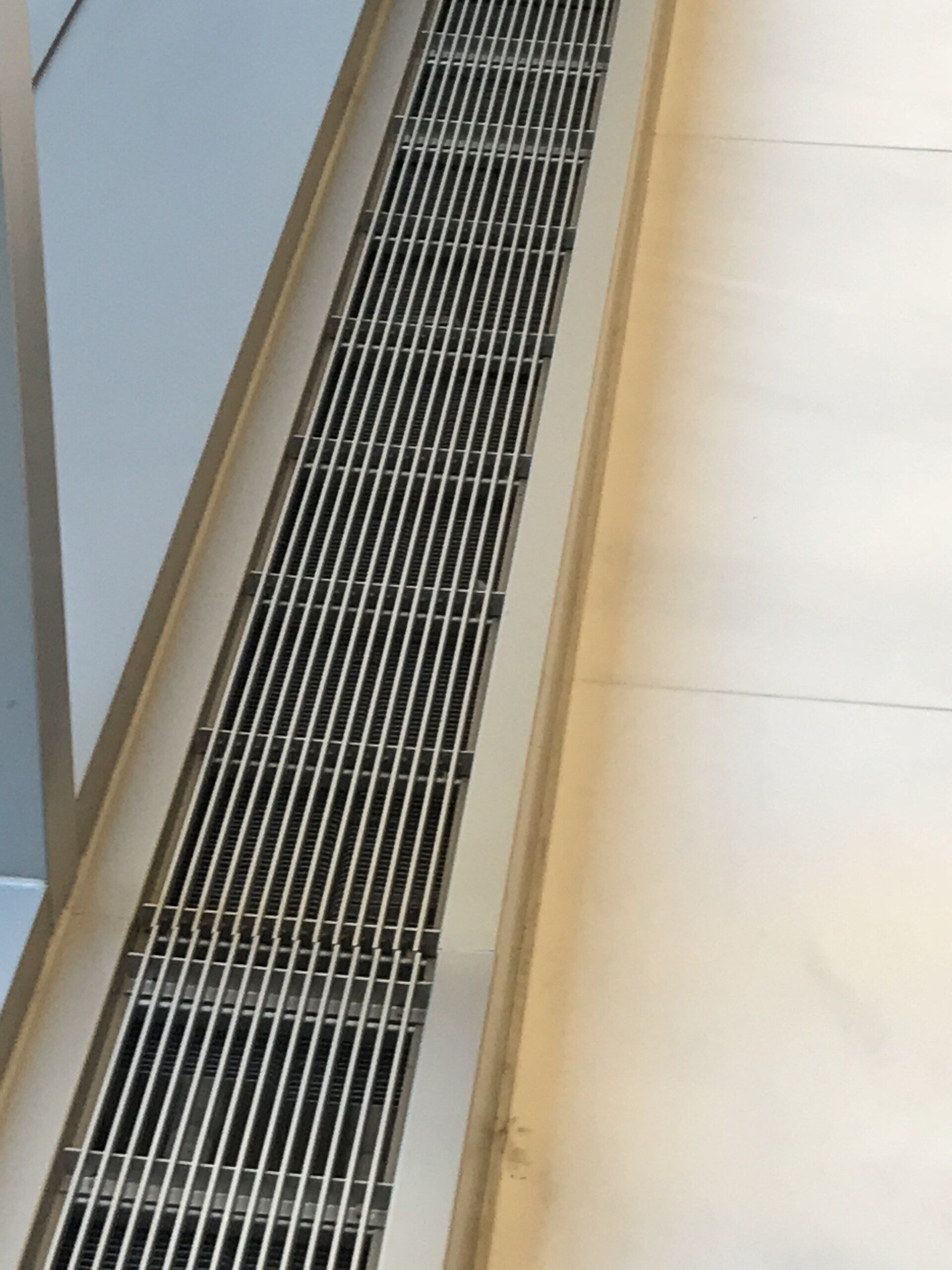 A stainless steel drain on the floor of a room.