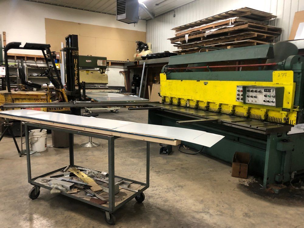 A machine is cutting a piece of metal in a workshop.