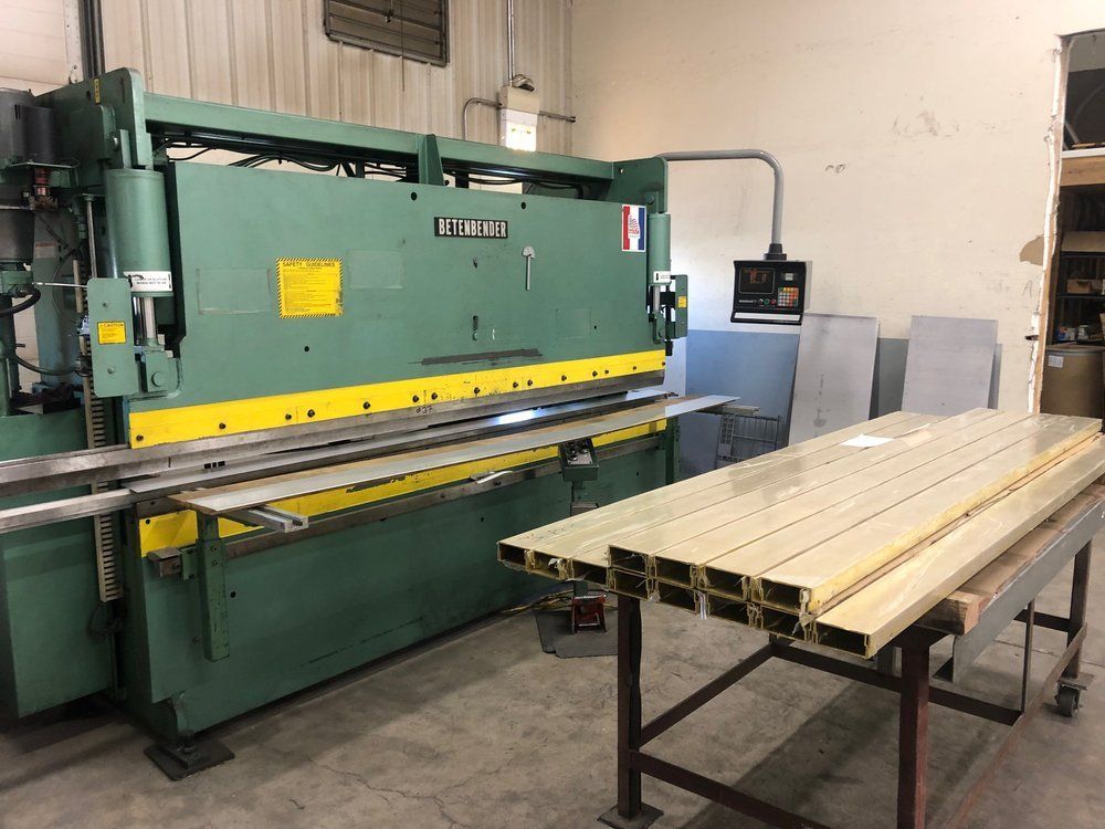 A green machine is sitting in a room next to a table.