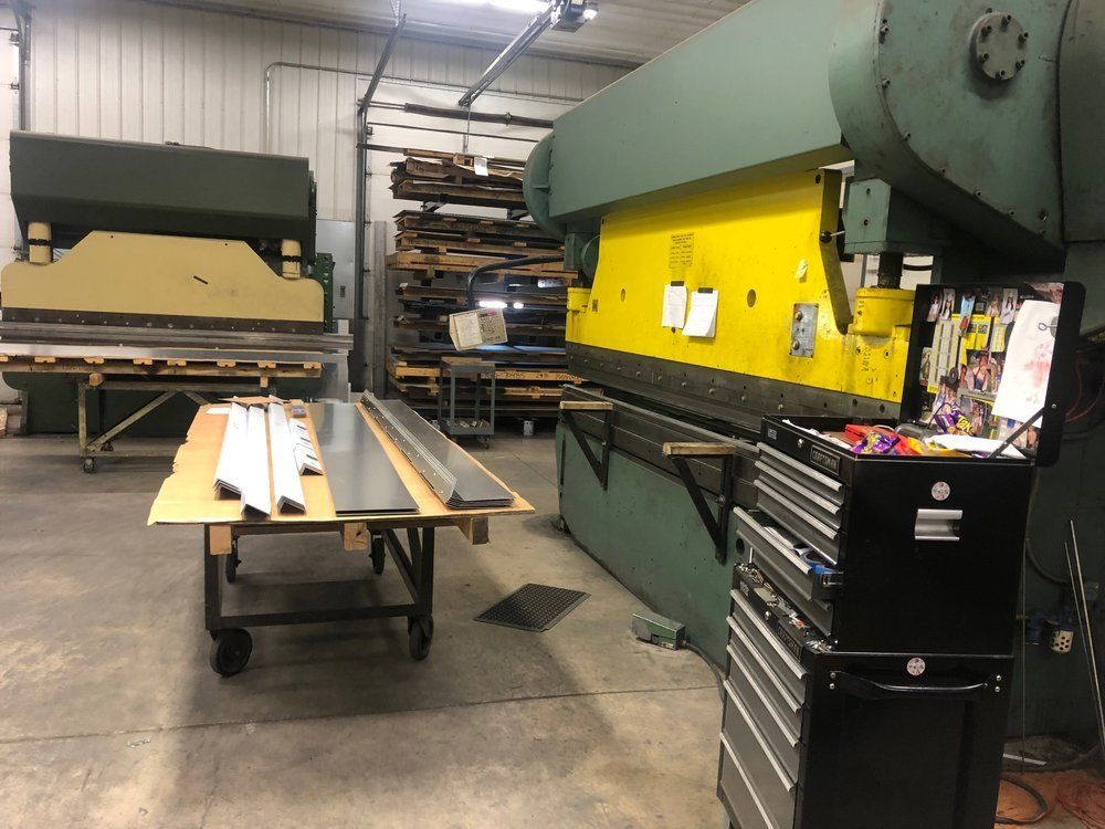 A warehouse with a yellow machine and a black toolbox