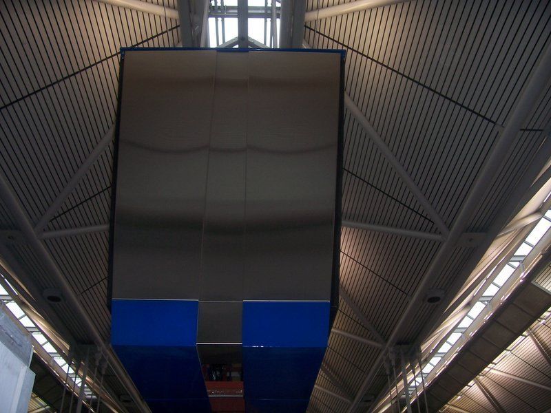 A large blue sign hangs from the ceiling of a building