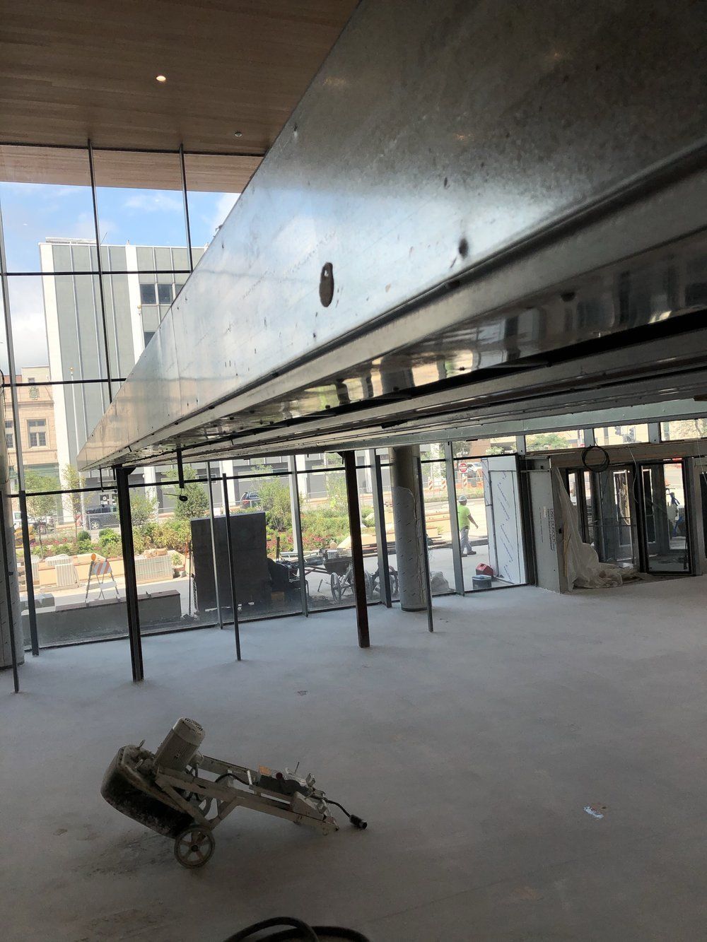 A large empty room with a lot of windows and a concrete floor.