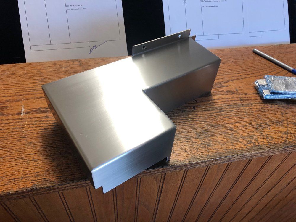 A piece of stainless steel is sitting on a wooden table.