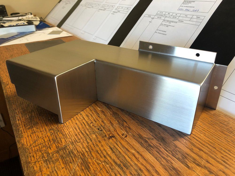A piece of stainless steel is sitting on a wooden table