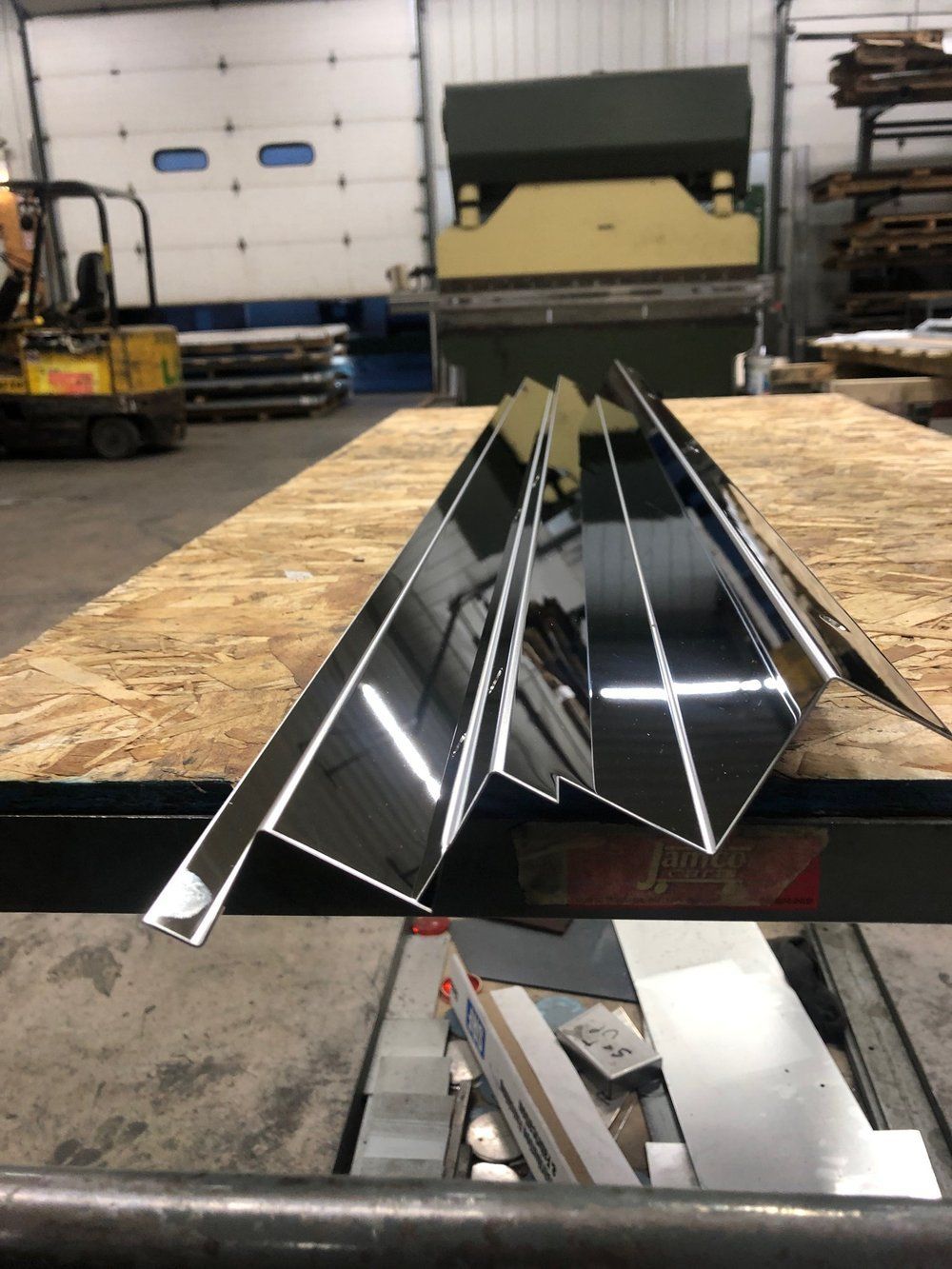 A piece of metal is sitting on top of a wooden table.