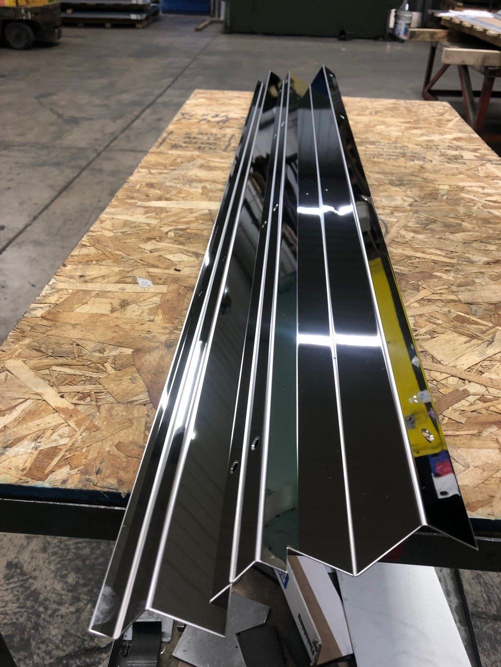 A long piece of metal is sitting on top of a wooden table.