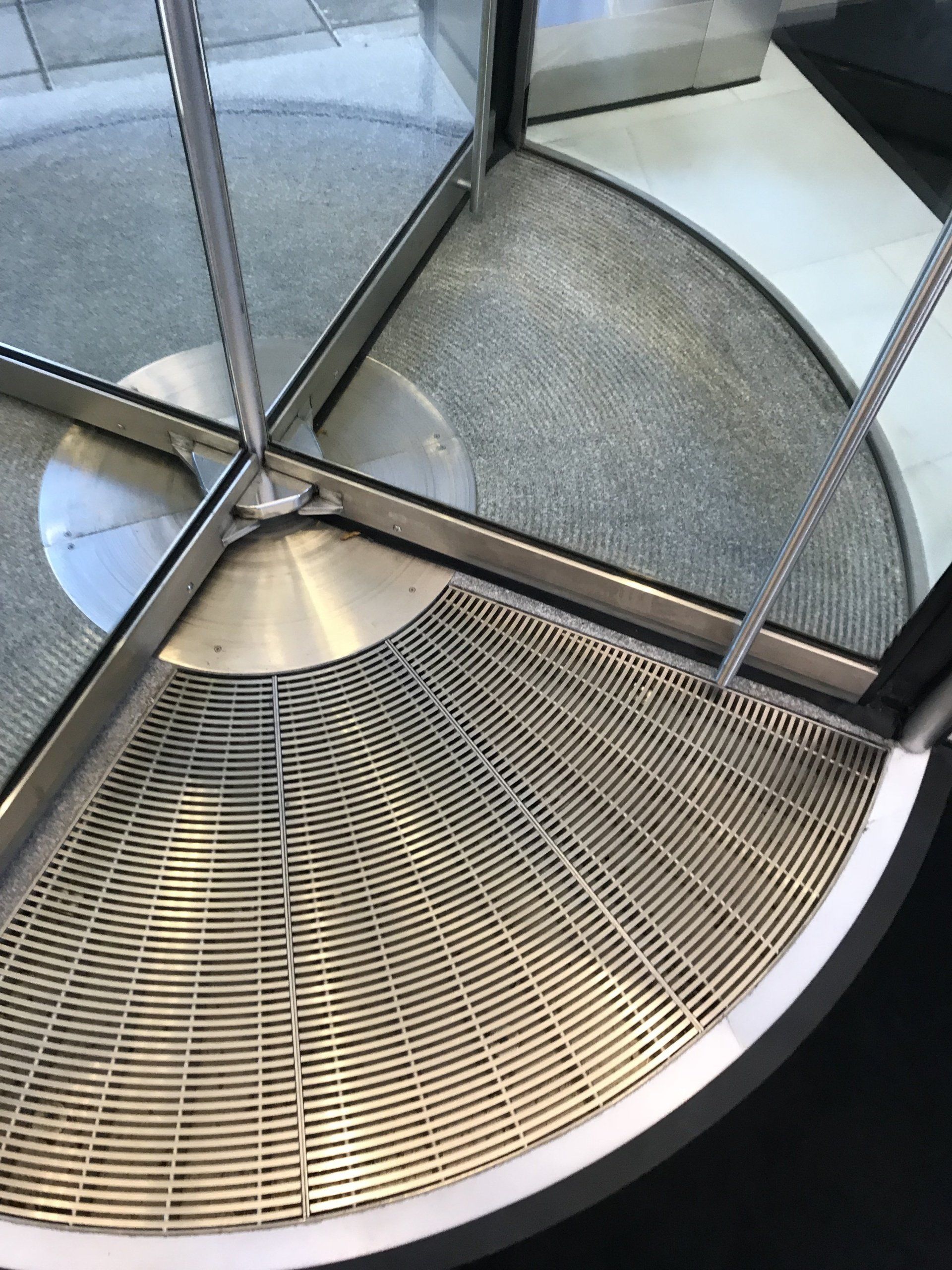 A close up of a metal grate in front of a glass door.