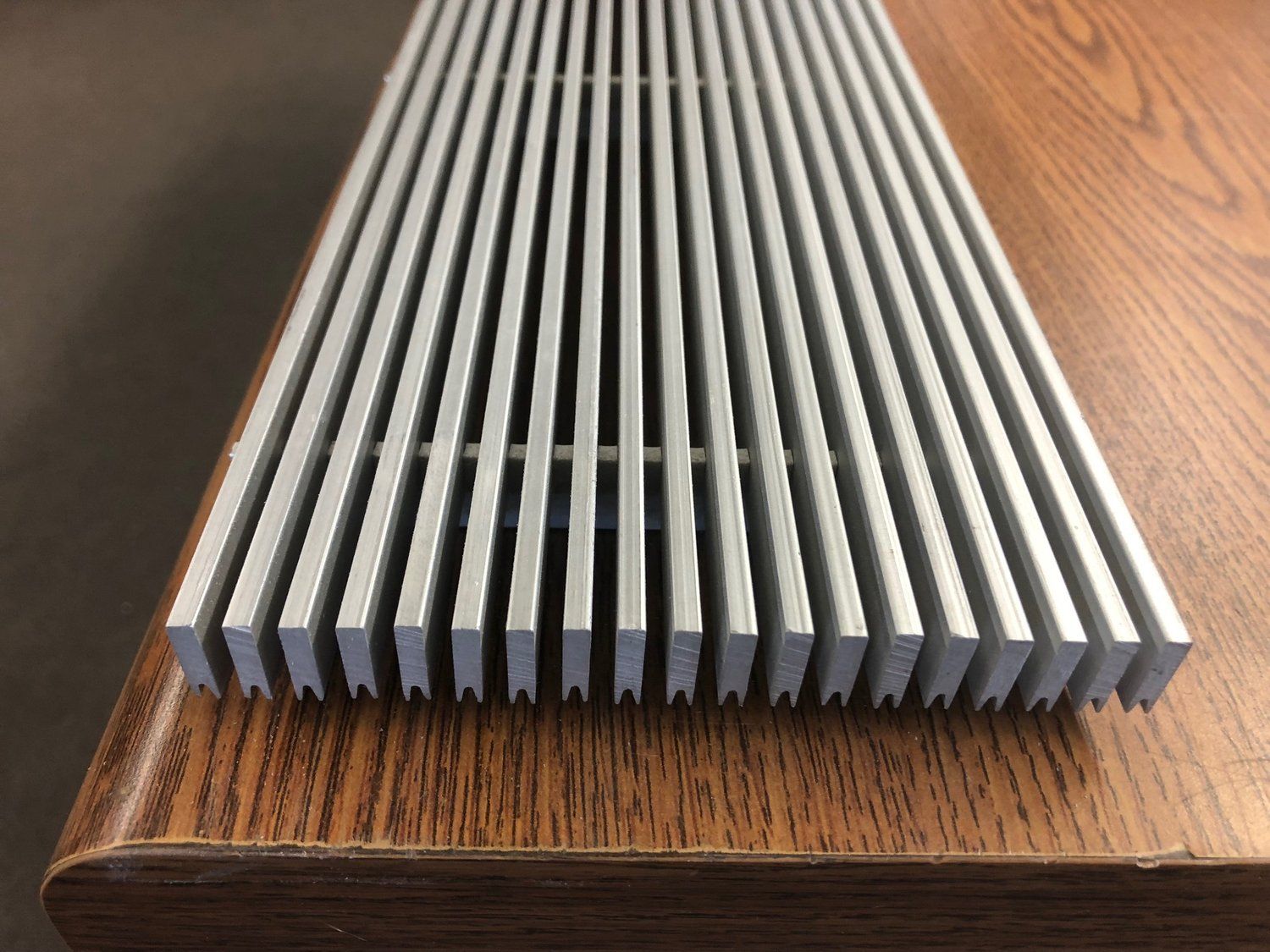 A metal grille is sitting on top of a wooden table.