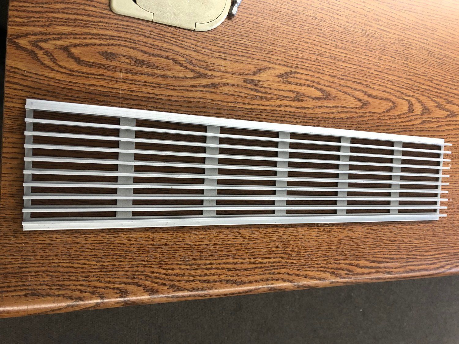 A metal grille is sitting on top of a wooden table.