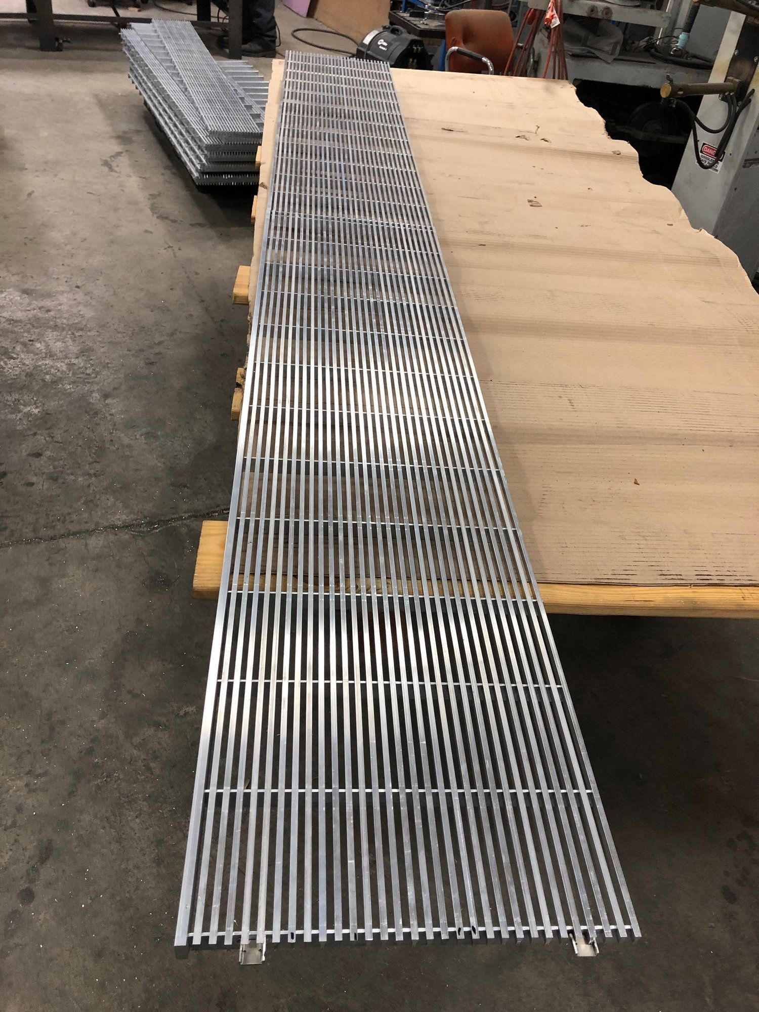 A metal grate is sitting on top of a wooden table.