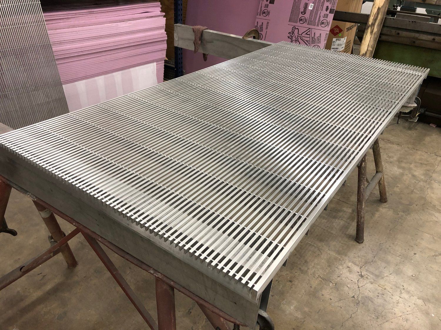 A metal table with holes in it is sitting on top of a wooden table.