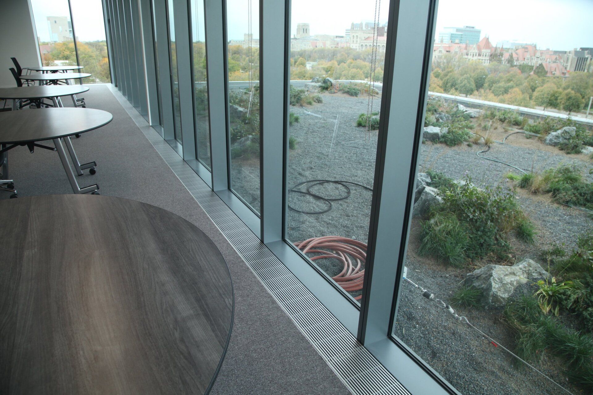 A room with tables and chairs and a large window