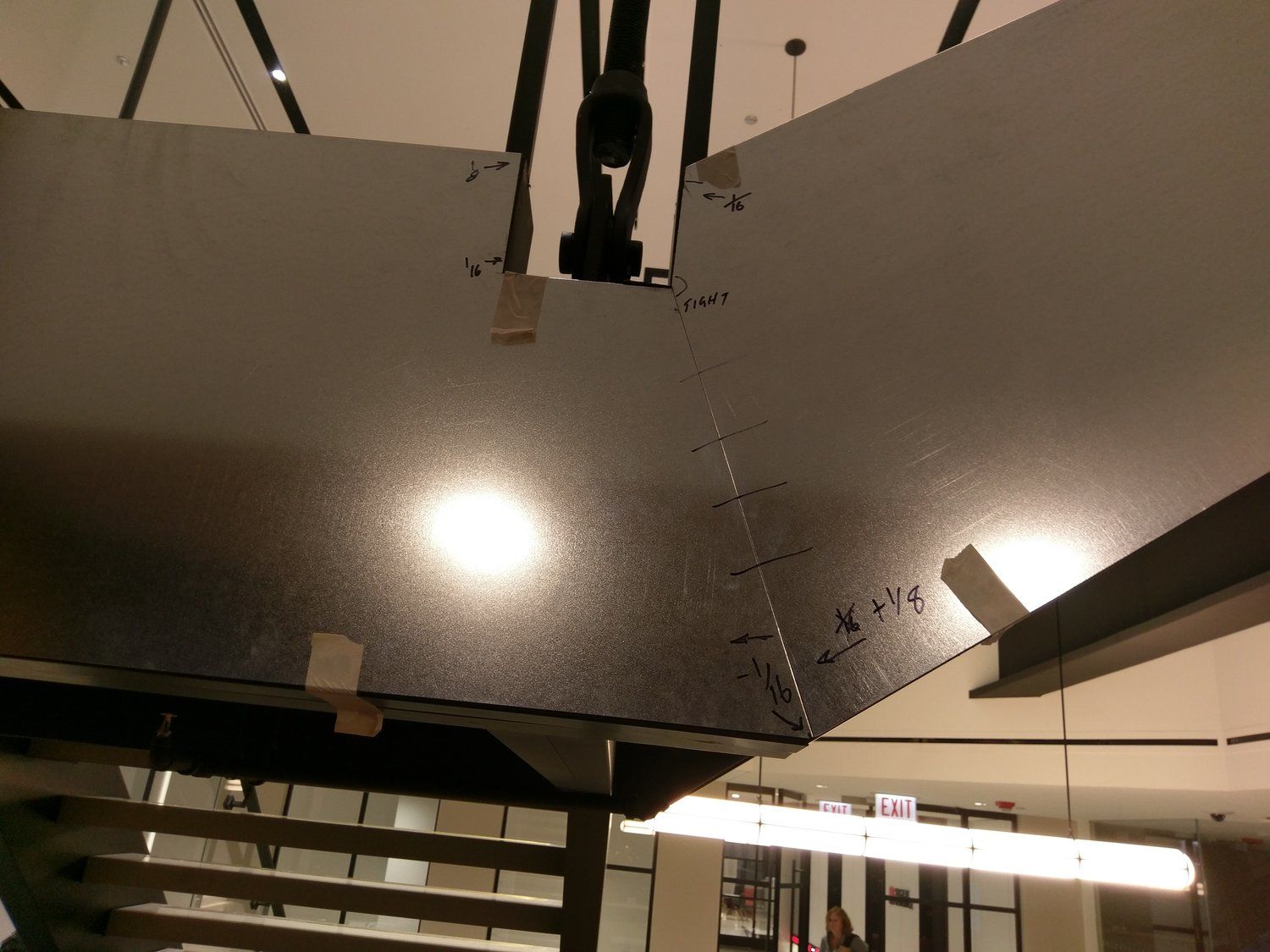 A large piece of metal is being lifted by a crane