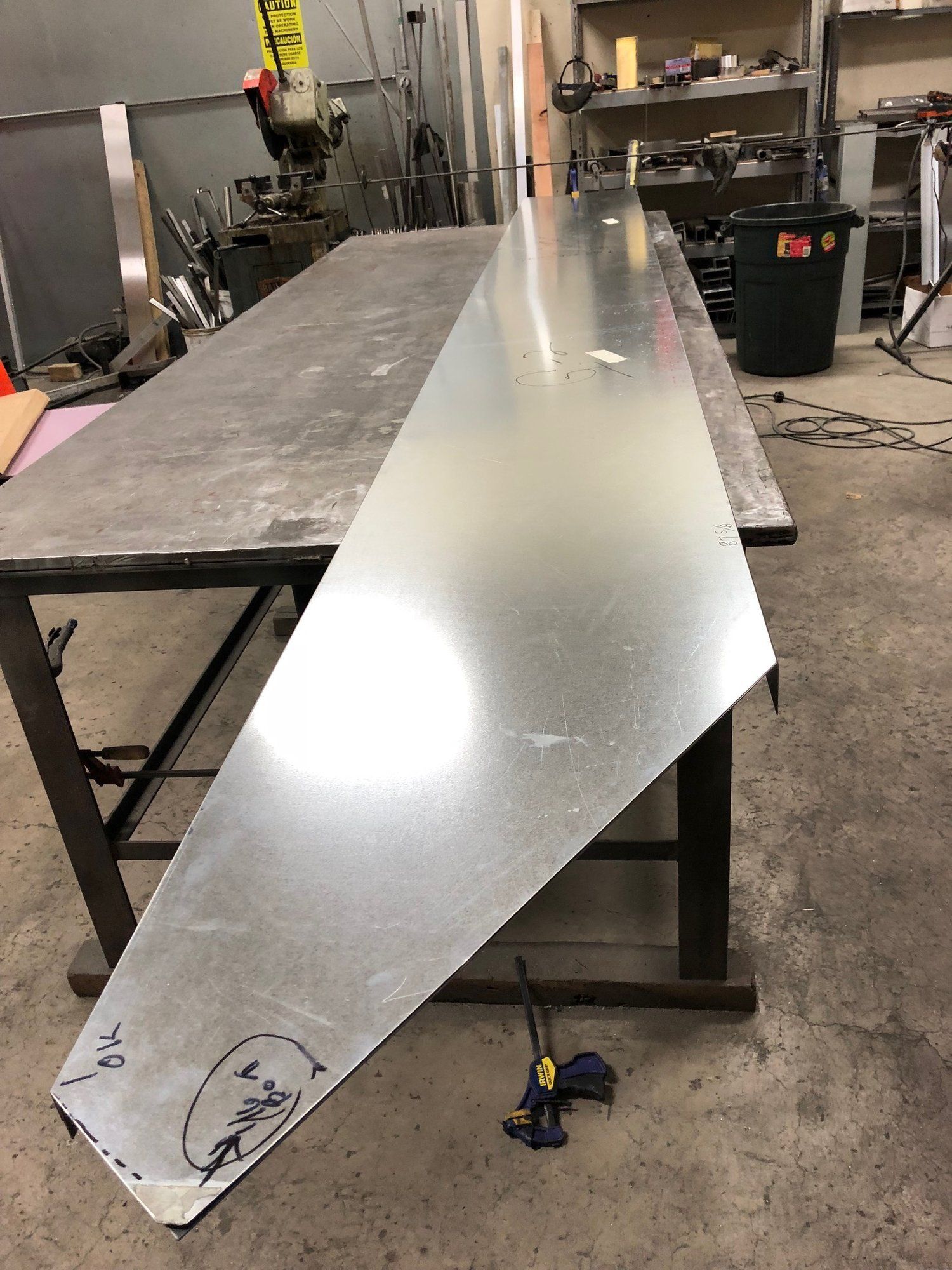 A piece of metal is sitting on top of a metal table.