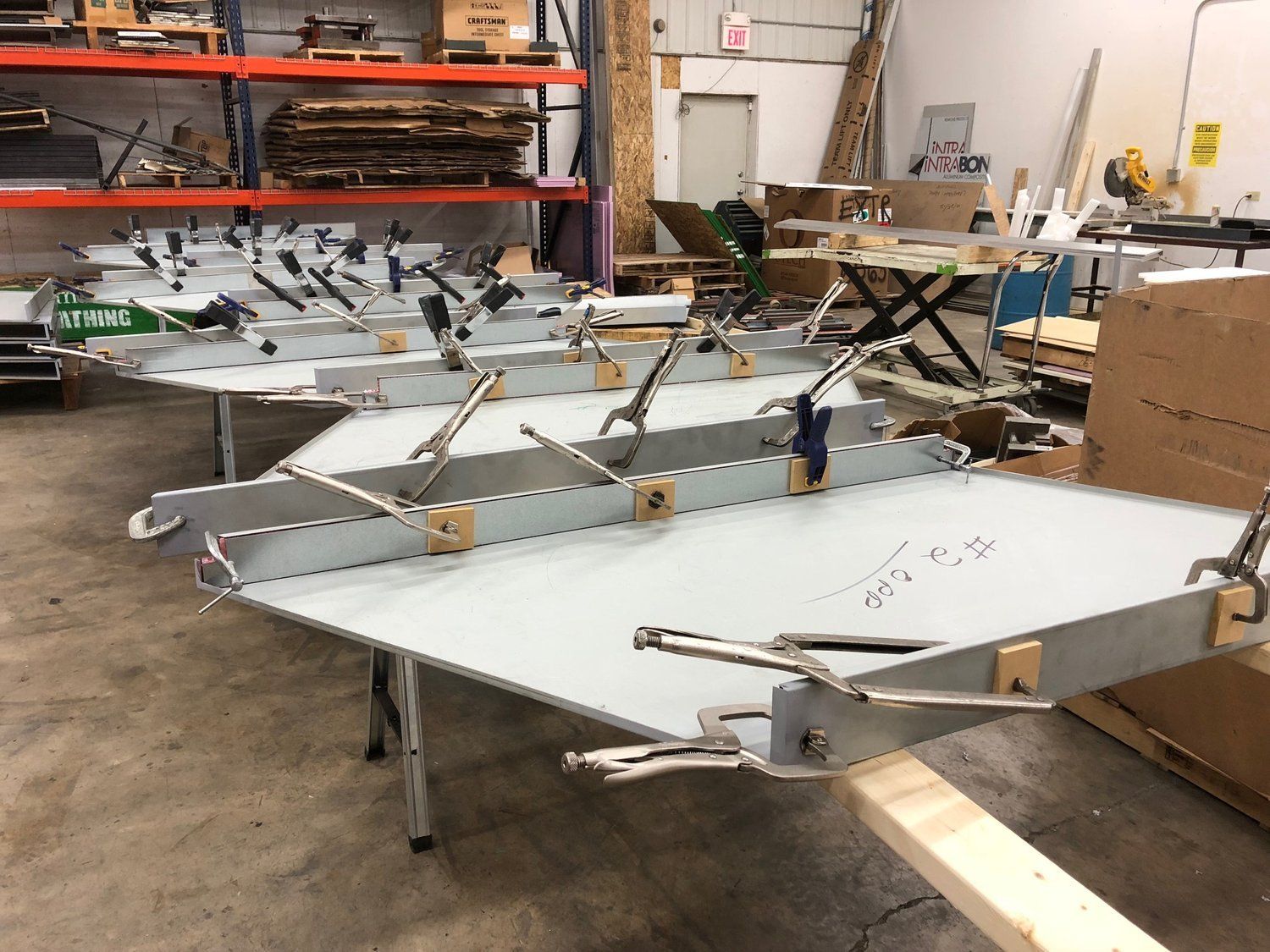 A row of clamps are sitting on a table in a workshop.
