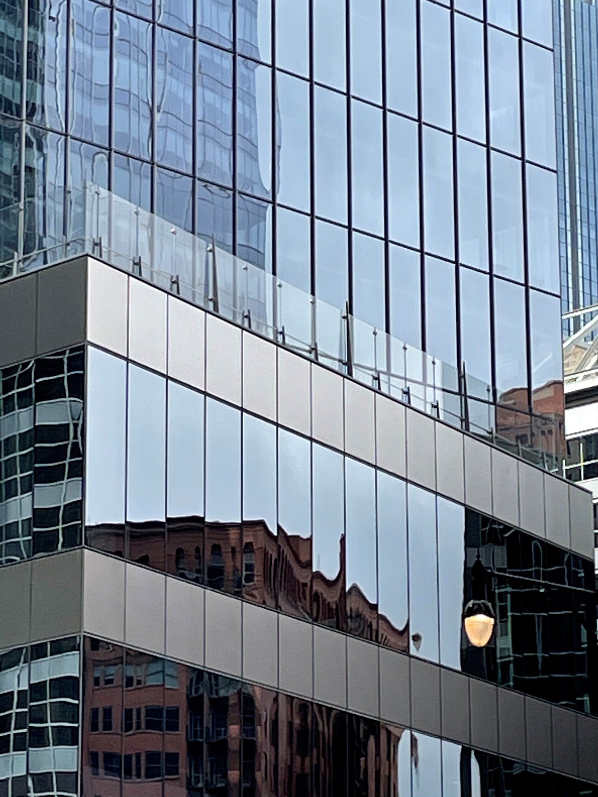 A building with a lot of windows and reflections of other buildings