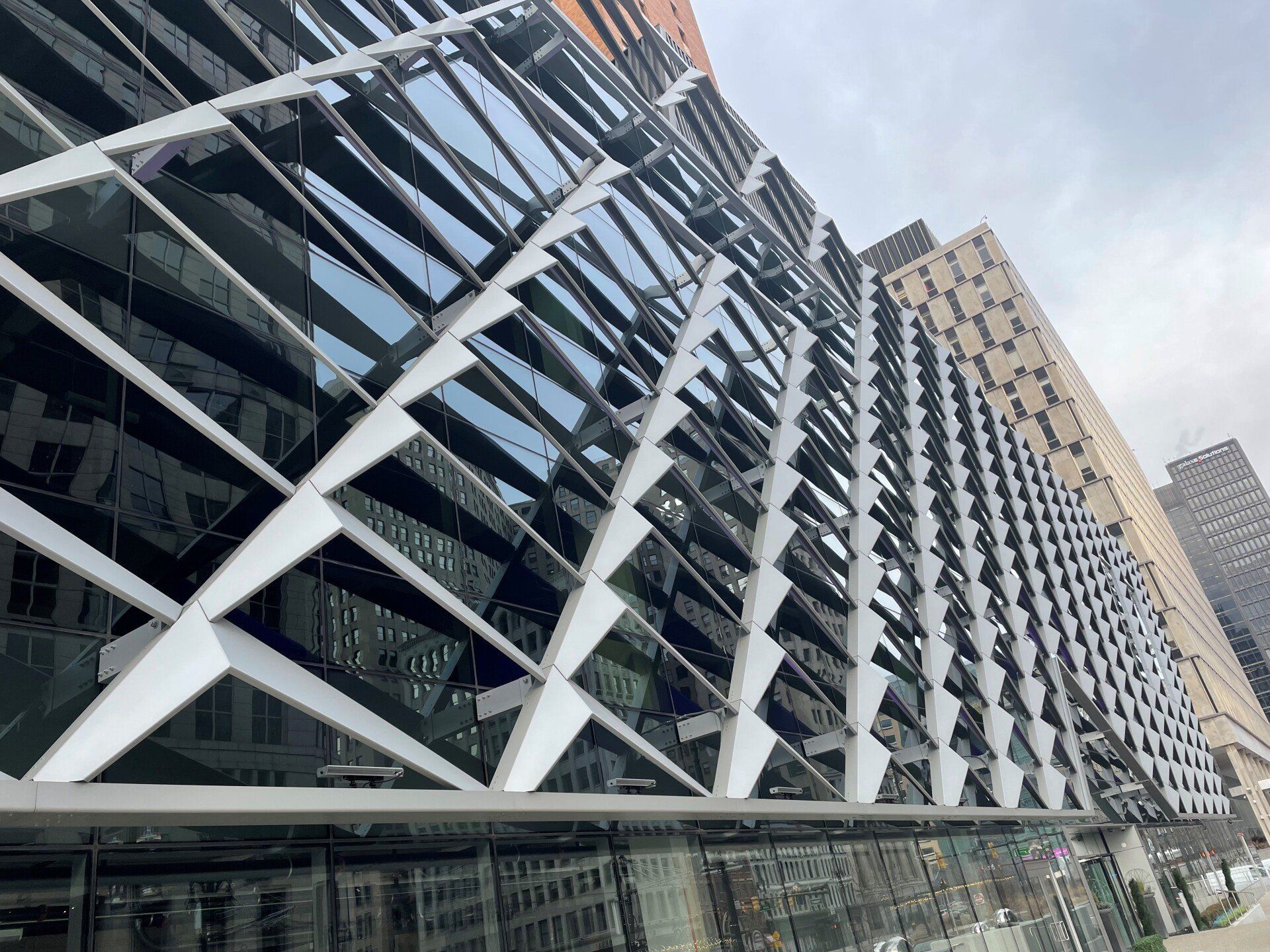 A large building with a lot of windows is surrounded by other buildings.