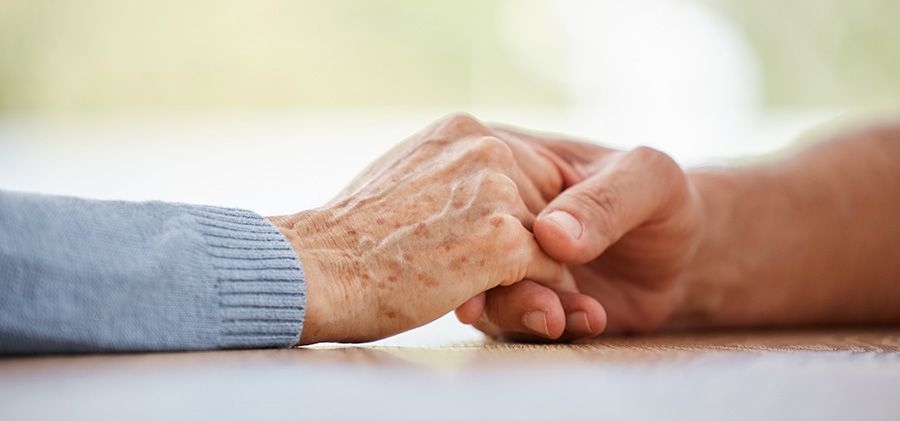 A close up of a person holding an older person 's hand.