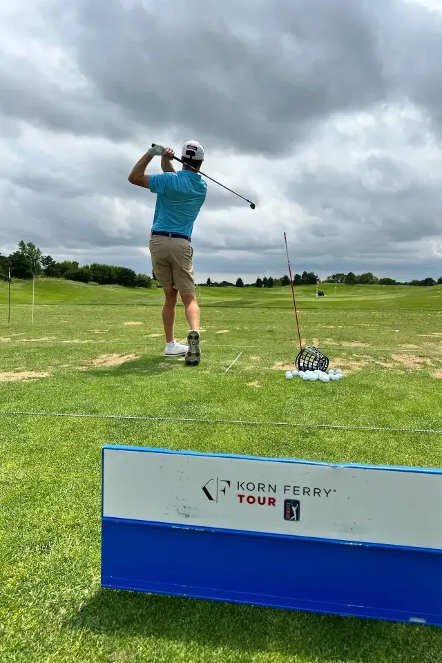 Danny Fisher professional golfer A man is swinging a golf club on a golf course.