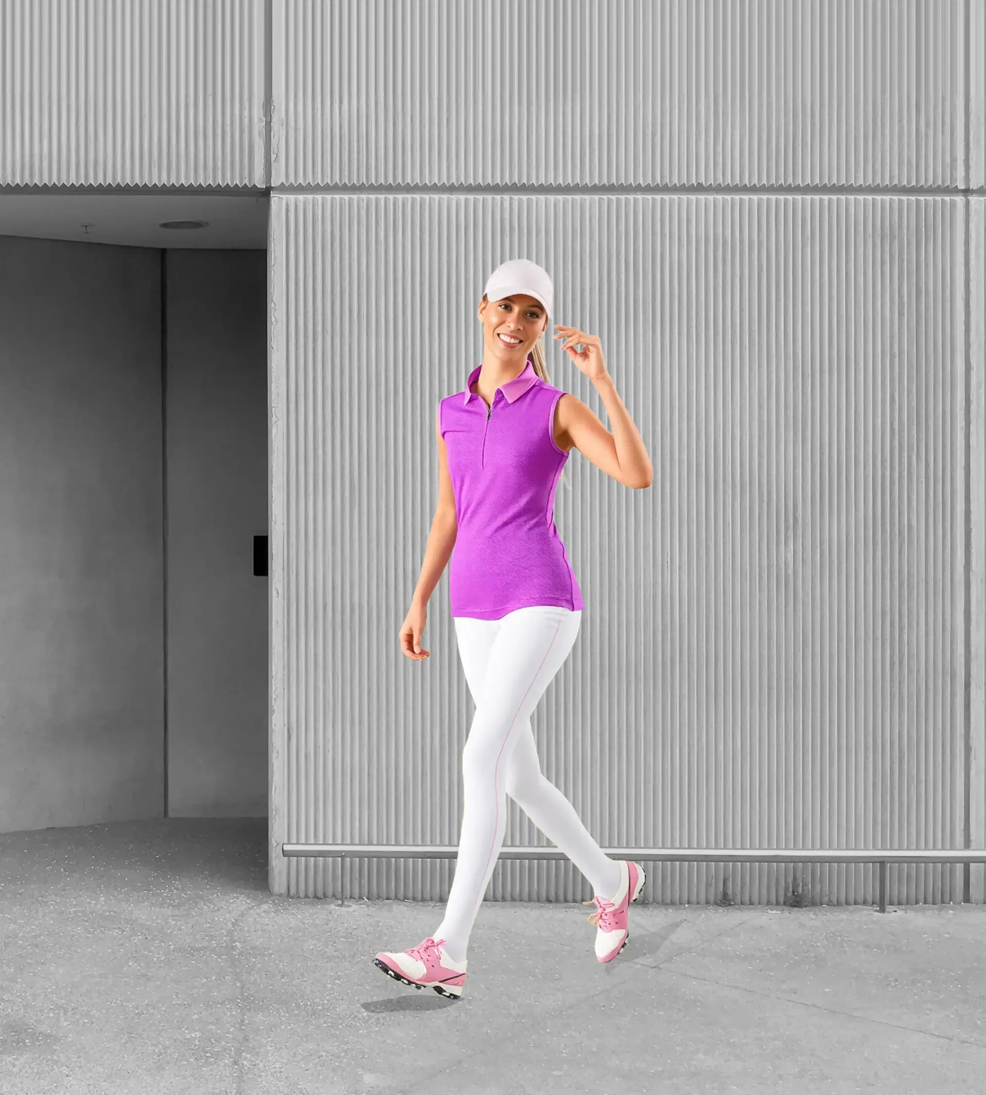 A woman in a purple shirt and white pants is walking in front of a building.