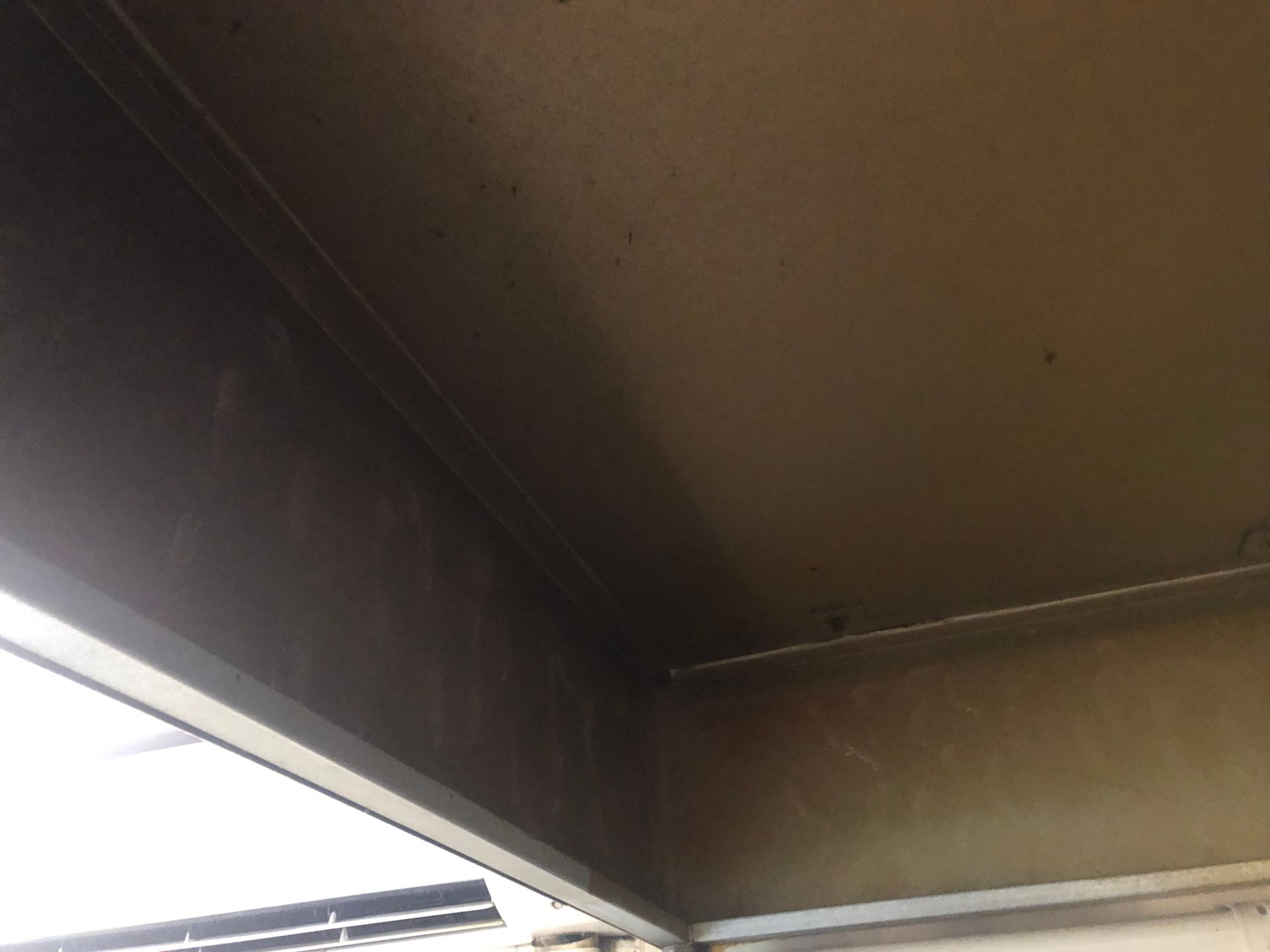 Corner of a structure with a gray beam and white trim; the walls are a light tan with some dark shading. - DM & MM Services, Exhaust Cleaning, Townsville, QLD.