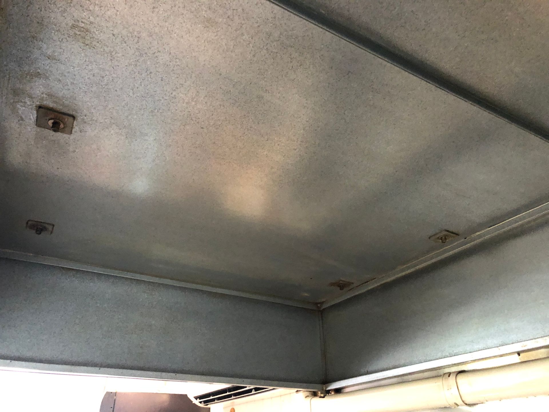 Corner of a structure with a gray beam and white trim; the walls are a clean showing the before and after result - DM & MM Services, Exhaust Cleaning, Townsville, QLD.