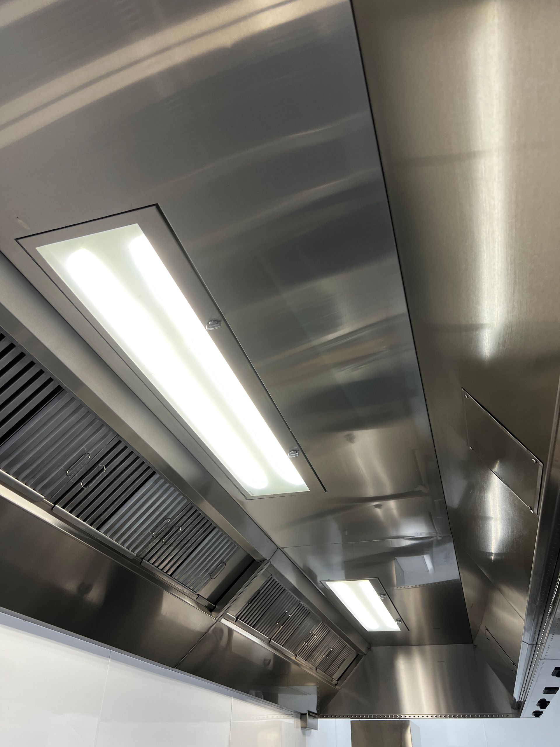 Stainless steel commercial kitchen hood with filters and lights— DM & MM Services Pty Ltd in Ayr, QLD