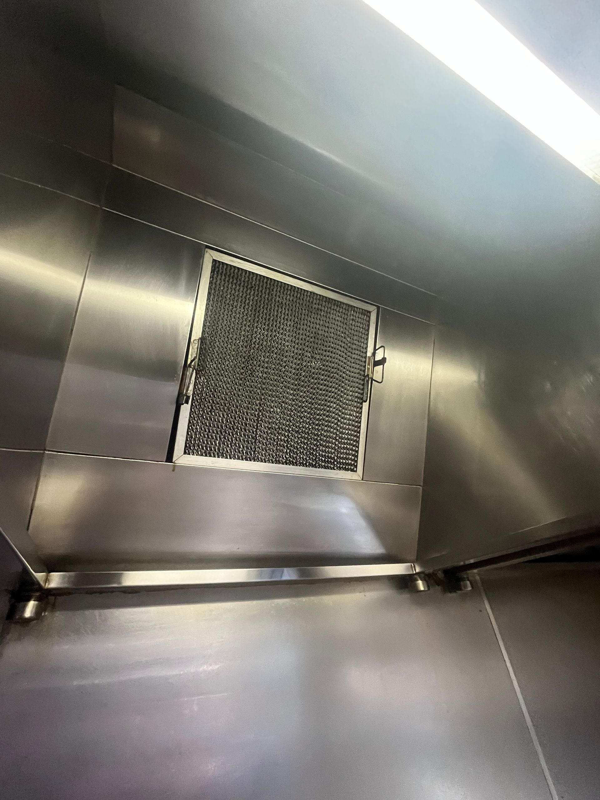 Stainless steel commercial kitchen hood with a filter.  DM & MM Services, Exhaust Cleaning, Townsville, QLD.