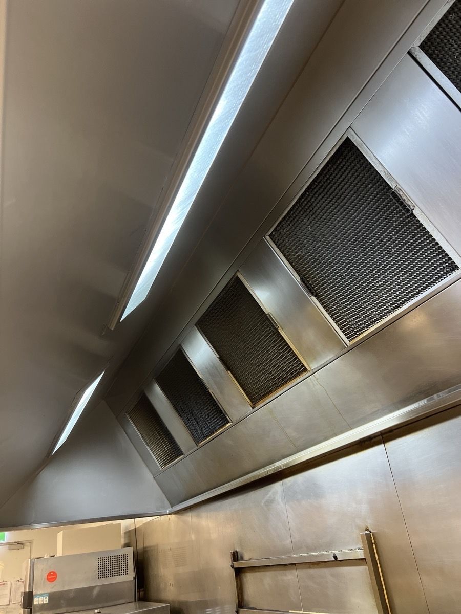 A Kitchen With Stainless Steel Appliances And A Hood — DM & MM Services Pty Ltd in Mount Louisa, QLD